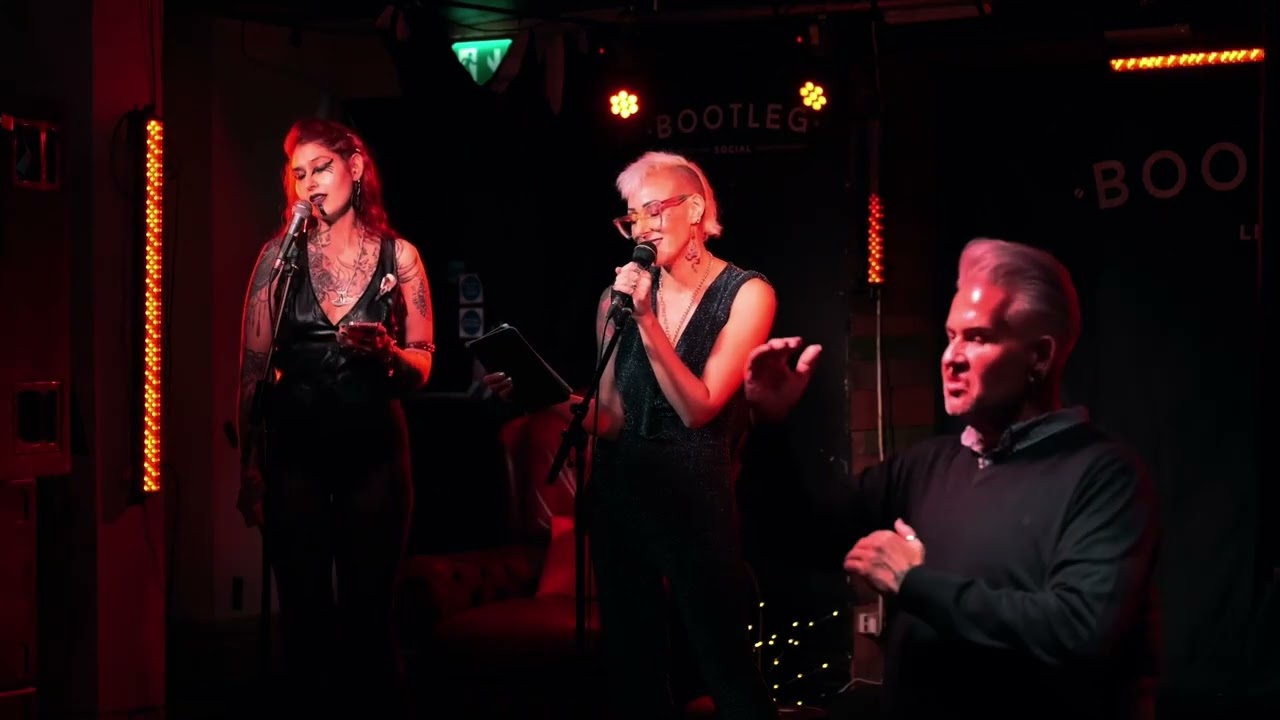 Jane onstage with Avadrian Night and a BSL interpreter during a live performance at Autumn Equinox in September 2024